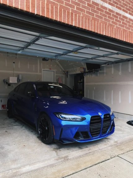 Blue BMW M3 with a deep, glossy finish parked in a garage